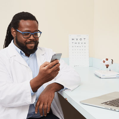 a doctor looking at a smartphone while sitting in his office